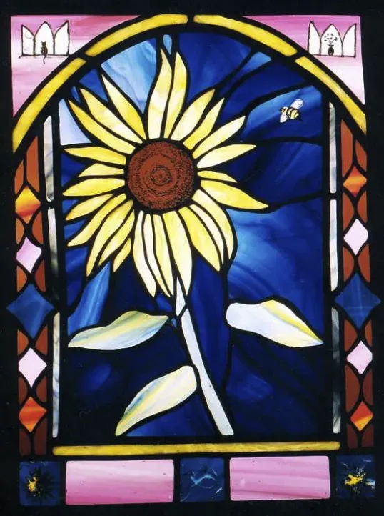 Stained glass artwork featuring a large sunflower with a bee.